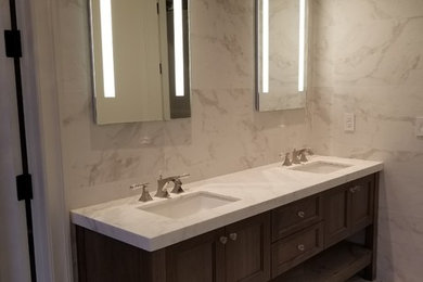 Large minimalist freestanding bathtub photo in New York with recessed-panel cabinets, medium tone wood cabinets and quartz countertops
