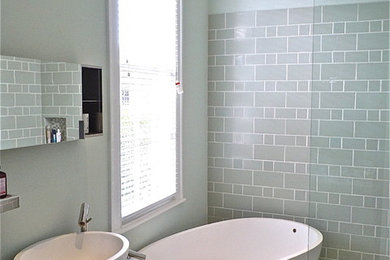 Inspiration for a modern master gray tile and glass tile mosaic tile floor bathroom remodel in New Orleans with a vessel sink, flat-panel cabinets, dark wood cabinets, wood countertops, a one-piece toilet and gray walls