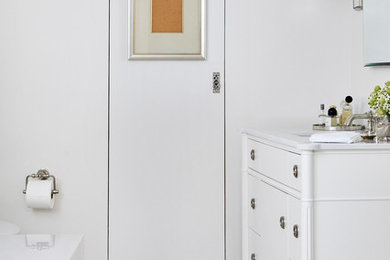 ロサンゼルスにあるおしゃれな浴室 (フラットパネル扉のキャビネット、白いキャビネット、白い壁、白い床) の写真