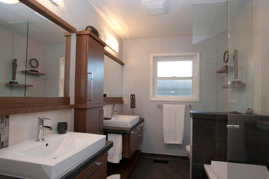 Bathroom - mid-sized modern master white tile and ceramic tile concrete floor and brown floor bathroom idea in Portland with flat-panel cabinets, dark wood cabinets, a two-piece toilet, gray walls, a vessel sink, granite countertops and a hinged shower door