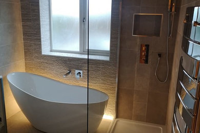Small contemporary family bathroom in Other with flat-panel cabinets, grey cabinets, a freestanding bath, a built-in shower, a two-piece toilet, beige tiles, porcelain tiles, beige walls, porcelain flooring, an integrated sink, laminate worktops, beige floors, an open shower and white worktops.