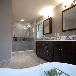 Example of a large classic master gray tile and porcelain tile porcelain tile bathroom design in DC Metro with recessed-panel cabinets, dark wood cabinets, a two-piece toilet, gray walls, an undermount sink and solid surface countertops