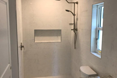 Modelo de cuarto de baño tradicional renovado de tamaño medio con ducha empotrada, baldosas y/o azulejos grises, baldosas y/o azulejos de porcelana, aseo y ducha, lavabo encastrado, encimera de granito, suelo gris, ducha abierta y encimeras grises