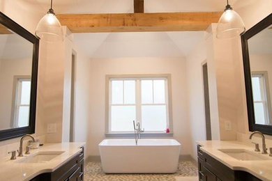 ローリーにあるトランジショナルスタイルのおしゃれなマスターバスルーム (濃色木目調キャビネット、置き型浴槽、クオーツストーンの洗面台) の写真