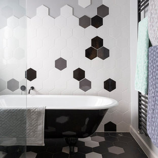 This is an example of a contemporary bathroom in Melbourne with a claw-foot tub, black and white tile, grey walls and multi-coloured floor.