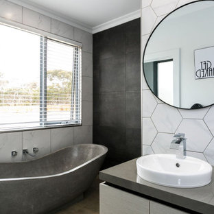 Design ideas for a mid-sized contemporary master bathroom in Adelaide with flat-panel cabinets, grey cabinets, a freestanding tub, an open shower, a one-piece toilet, gray tile, porcelain tile, grey walls, porcelain floors, a drop-in sink, solid surface benchtops, brown floor, an open shower, grey benchtops, a single vanity and a built-in vanity.