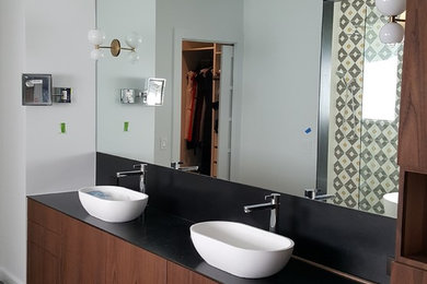 Inspiration for a medium sized contemporary ensuite bathroom in Austin with flat-panel cabinets, dark wood cabinets, white walls, slate flooring, a vessel sink, solid surface worktops and black floors.
