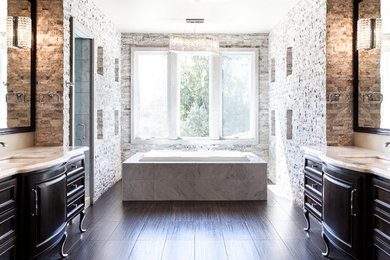 Mediterranean bathroom in Sacramento with a submerged sink, freestanding cabinets, dark wood cabinets, a built-in bath, grey tiles, stone tiles, white walls and porcelain flooring.