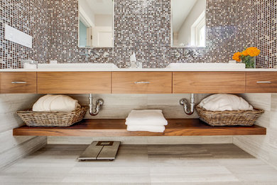Inspiration for a modern bathroom in San Francisco with medium wood cabinets, engineered stone worktops, grey tiles, a vessel sink and limestone flooring.