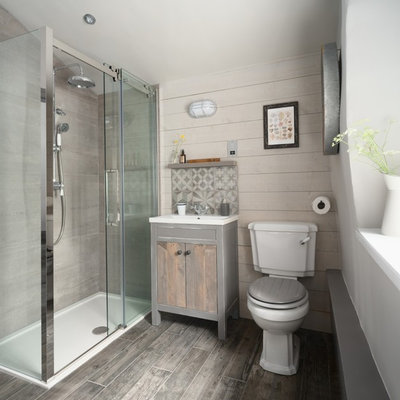 Small beach style gray tile gray floor bathroom photo in Other with flat-panel cabinets, light wood cabinets, a two-piece toilet, a console sink and beige walls