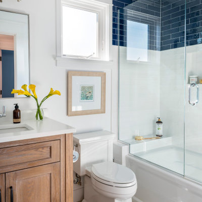 Inspiration for a coastal blue tile and white tile beige floor and single-sink bathroom remodel in Boston with shaker cabinets, medium tone wood cabinets, white walls, an undermount sink, a hinged shower door, white countertops and a freestanding vanity
