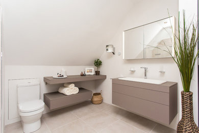 Mittelgroßes Modernes Badezimmer mit flächenbündigen Schrankfronten, braunen Schränken, Toilette mit Aufsatzspülkasten, weißer Wandfarbe, Wandwaschbecken und grauem Boden in Hampshire