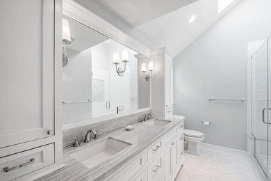 Alcove shower - mid-sized transitional master white tile and ceramic tile marble floor and white floor alcove shower idea in New York with recessed-panel cabinets, white cabinets, a two-piece toilet, gray walls, marble countertops, a hinged shower door and gray countertops