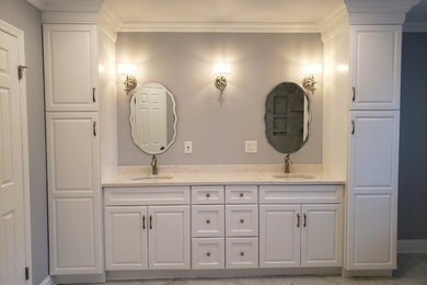 Réalisation d'une salle de bain avec des portes de placard blanches, un plan de toilette en granite, un sol gris et un plan de toilette gris.
