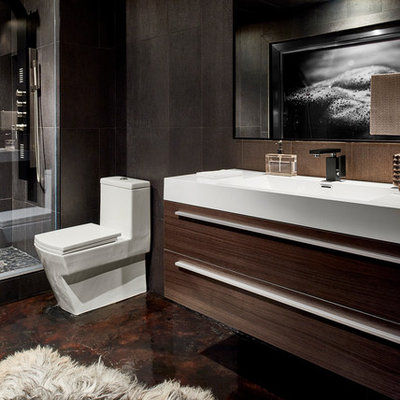 Mid-sized minimalist master gray tile and cement tile concrete floor alcove shower photo in Atlanta with flat-panel cabinets, dark wood cabinets, a one-piece toilet, gray walls and an integrated sink