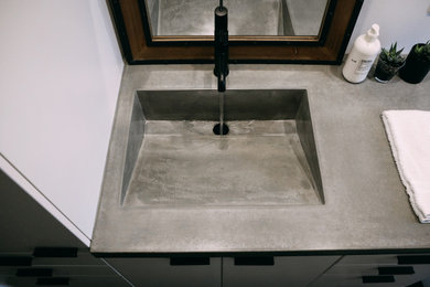 Ejemplo de cuarto de baño principal, único y a medida vintage de tamaño medio con armarios con paneles lisos, puertas de armario blancas, lavabo integrado, encimera de cemento y encimeras grises