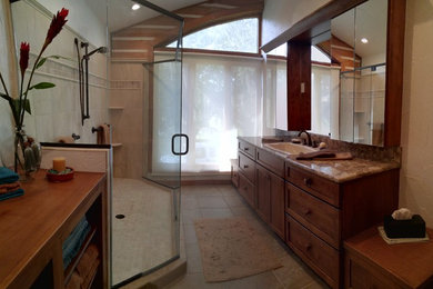 Cette photo montre une grande salle de bain principale craftsman en bois foncé avec un lavabo posé, un placard à porte shaker, un plan de toilette en verre, une douche ouverte, WC séparés, un carrelage beige, des carreaux de porcelaine, un mur blanc et un sol en carrelage de porcelaine.