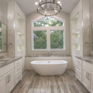 Large transitional master white tile and porcelain tile medium tone wood floor and gray floor bathroom photo in Houston with shaker cabinets, white cabinets, granite countertops, gray walls, an undermount sink and a hinged shower door