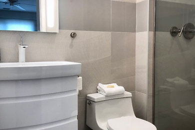 Example of a small trendy 3/4 beige tile and ceramic tile ceramic tile and gray floor alcove shower design in Philadelphia with furniture-like cabinets, white cabinets, a one-piece toilet, beige walls, an integrated sink, a hinged shower door, white countertops and quartz countertops