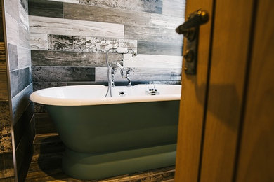 ロンドンにあるお手頃価格の中くらいなトラディショナルスタイルのおしゃれなマスターバスルーム (置き型浴槽、シャワー付き浴槽	、一体型トイレ	、黒い壁、磁器タイルの床、ベッセル式洗面器) の写真