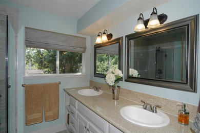 Klassisk inredning av ett litet en-suite badrum, med ett nedsänkt handfat, luckor med upphöjd panel, grå skåp, granitbänkskiva, en toalettstol med hel cisternkåpa, grå kakel, porslinskakel, blå väggar och klinkergolv i porslin
