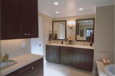 Drop-in bathtub - mid-sized transitional master beige tile and stone tile limestone floor drop-in bathtub idea in San Francisco with an undermount sink, recessed-panel cabinets, dark wood cabinets, marble countertops and beige walls