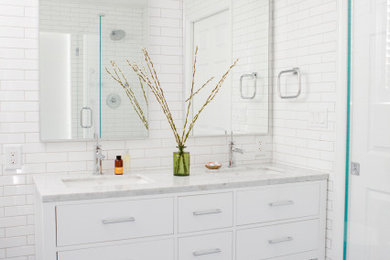Minimalist master white tile and subway tile blue floor and double-sink bathroom photo in New York with beaded inset cabinets, white cabinets, a two-piece toilet, white walls, a drop-in sink, marble countertops, a hinged shower door, white countertops and a freestanding vanity