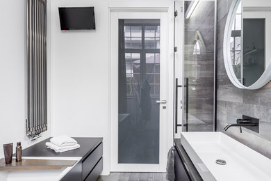 Bathroom - mid-sized modern master gray tile and porcelain tile porcelain tile and gray floor bathroom idea in Atlanta with flat-panel cabinets, black cabinets, white walls, a vessel sink, quartz countertops, a hinged shower door and gray countertops