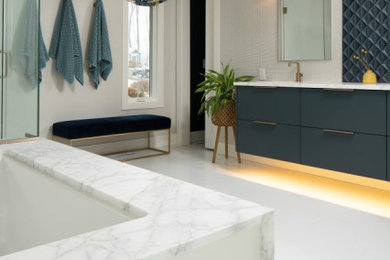 Inspiration for a mid-sized modern master blue tile and glass tile porcelain tile, white floor and double-sink bathroom remodel in Minneapolis with flat-panel cabinets, blue cabinets, an undermount tub, a bidet, gray walls, an undermount sink, marble countertops, a hinged shower door, white countertops and a floating vanity