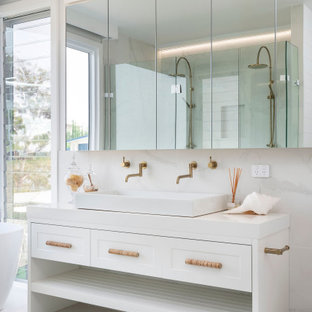 Photo of a contemporary bathroom in Newcastle - Maitland with furniture-like cabinets, white cabinets, a freestanding tub, white tile, a trough sink, white floor, white benchtops and a double vanity.