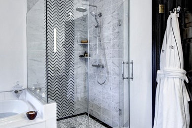 Example of a mid-sized trendy master marble tile marble floor and black floor corner shower design in Philadelphia with furniture-like cabinets, a hot tub, a one-piece toilet, white walls, a vessel sink, marble countertops and a hinged shower door
