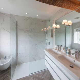 Design ideas for a medium sized country ensuite bathroom in Oxfordshire with a walk-in shower, white tiles, white walls, porcelain flooring, a console sink, grey floors, an open shower, flat-panel cabinets, white cabinets and a bidet.