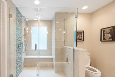 Inspiration for a large modern master ceramic tile and beige tile ceramic tile doorless shower remodel in New York with dark wood cabinets, an undermount sink, quartz countertops, furniture-like cabinets, a one-piece toilet and beige walls