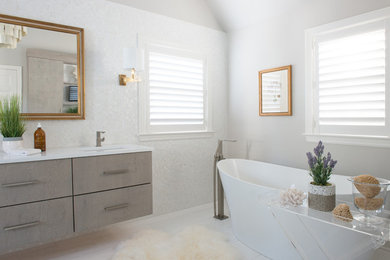 Example of a large trendy master white tile and porcelain tile limestone floor and white floor bathroom design in New York with flat-panel cabinets, gray cabinets, quartz countertops, a two-piece toilet, gray walls and an undermount sink
