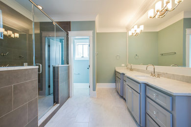 Huge transitional master ceramic tile doorless shower photo in Charleston with a drop-in sink, raised-panel cabinets, blue cabinets, marble countertops and green walls