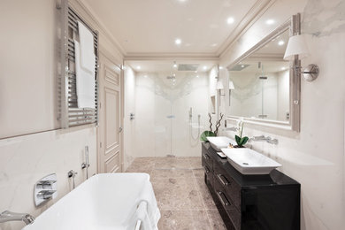 Traditional ensuite bathroom in London with flat-panel cabinets, black cabinets, a freestanding bath, a built-in shower, white tiles, white walls, a vessel sink, brown floors, a hinged door and black worktops.