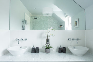 Inspiration for a medium sized contemporary ensuite bathroom in Berkshire with flat-panel cabinets, white cabinets, a walk-in shower, a two-piece toilet, white tiles, porcelain tiles, white walls, ceramic flooring, a vessel sink, marble worktops, black floors, an open shower and white worktops.