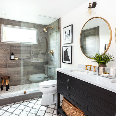 Small cottage 3/4 multicolored tile and stone tile marble floor doorless shower photo in Sacramento with furniture-like cabinets, black cabinets, a one-piece toilet, white walls, an undermount sink and marble countertops