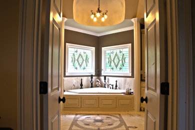 Bathroom - large traditional master beige tile and stone tile travertine floor bathroom idea in Atlanta with an undermount sink, raised-panel cabinets, granite countertops, brown walls, beige cabinets and a two-piece toilet