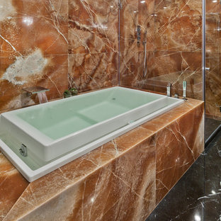 Bild på ett stort funkis en-suite badrum, med möbel-liknande, grå skåp, en jacuzzi, en öppen dusch, en toalettstol med separat cisternkåpa, orange kakel, stenhäll, orange väggar, marmorgolv och ett fristående handfat