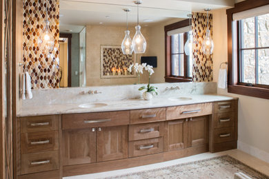 Photo of a classic ensuite bathroom in Denver with flat-panel cabinets, medium wood cabinets, an alcove shower, multi-coloured tiles, mosaic tiles, beige walls, marble flooring, a submerged sink, marble worktops, white floors, a hinged door, white worktops, double sinks and a built in vanity unit.