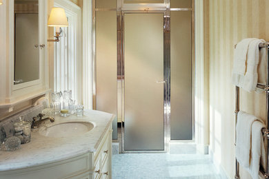 Inspiration for a mid-sized timeless 3/4 mosaic tile floor and multicolored floor alcove shower remodel in New York with raised-panel cabinets, white cabinets, yellow walls, an undermount sink, marble countertops and a hinged shower door