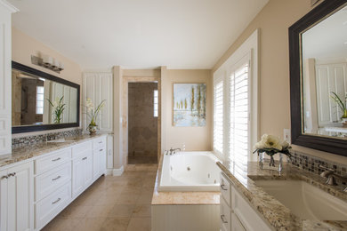 Photo of a contemporary bathroom in Dallas with a submerged sink, raised-panel cabinets, white cabinets, granite worktops, a built-in bath, beige tiles, beige walls and ceramic flooring.