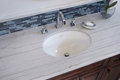 Mid-sized master marble floor, white floor and single-sink bathroom photo in Los Angeles with raised-panel cabinets, white cabinets, white walls, a drop-in sink, quartzite countertops, white countertops and a built-in vanity