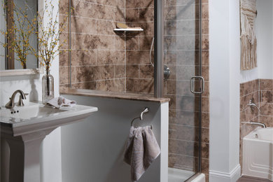 Example of a transitional master beige tile and limestone tile brown floor bathroom design in Chicago with a pedestal sink and a hinged shower door