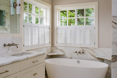 Example of a minimalist multicolored tile freestanding bathtub design in Seattle with beige walls