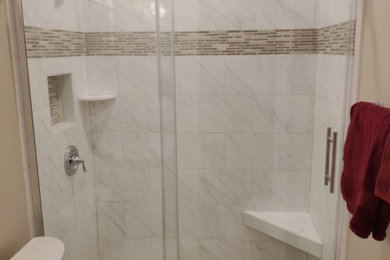 他の地域にある小さなトランジショナルスタイルのおしゃれな浴室 (白いキャビネット、アルコーブ型シャワー、分離型トイレ、ベージュの壁、磁器タイルの床、珪岩の洗面台、引戸のシャワー、洗面台1つ) の写真