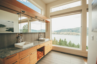 Mid-sized trendy master beige tile and porcelain tile porcelain tile and gray floor bathroom photo in Vancouver with a vessel sink, flat-panel cabinets, medium tone wood cabinets, beige walls, granite countertops and gray countertops