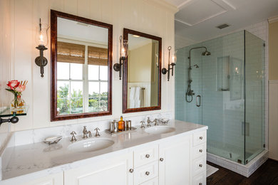 Inspiration for a timeless white tile and subway tile dark wood floor corner shower remodel in Los Angeles with raised-panel cabinets, white cabinets and an undermount sink