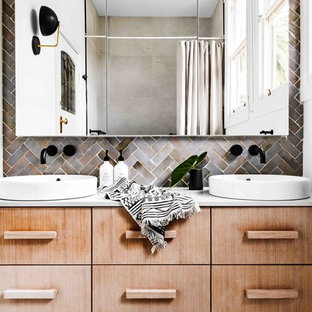 Design ideas for an eclectic bathroom in Melbourne with flat-panel cabinets, light wood cabinets, gray tile, white walls, a vessel sink and white benchtops.